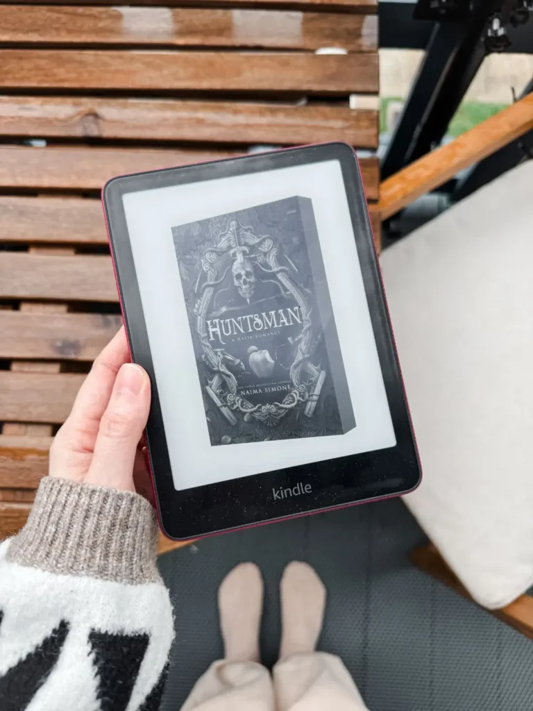 October 2025 Romance Book Releases - in the photo an e-reader with the cover of Huntsman by Naima Simone on it.
