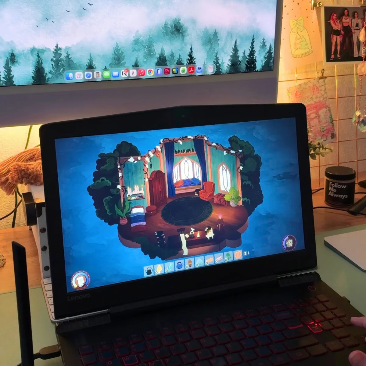 Songs of Glimmerwick open on a laptop at a desk, showing a cozy dorm room with tall arched windows, a round rug and candles, with string lights and a photo grid on the wall behind